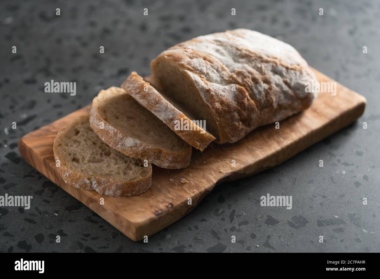 Ciabatta rustica a fette con farina di segale su tavola di oliva Foto Stock