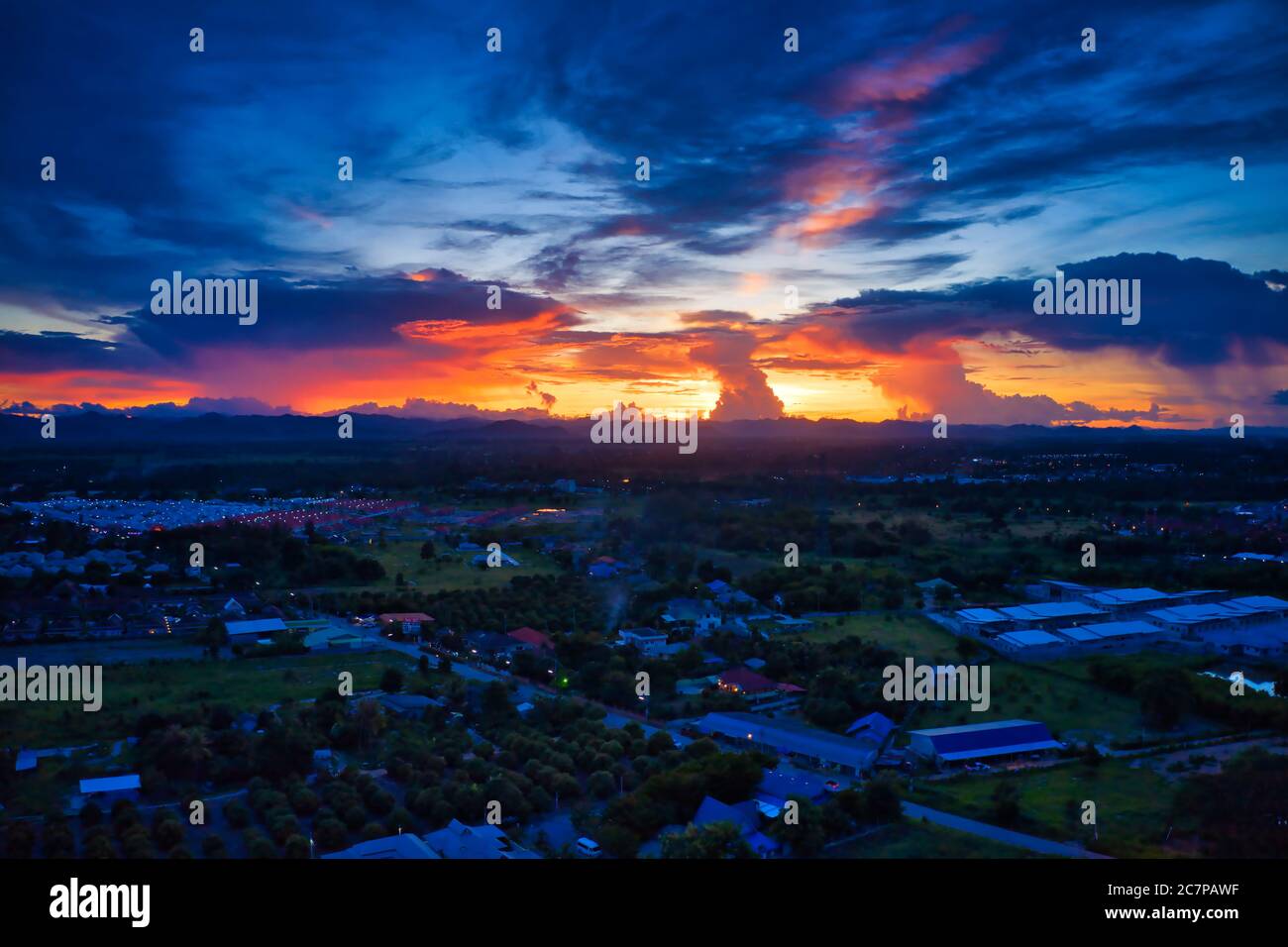 Questa foto unica mostra il paesaggio posteriore di Hua Hin in Thailandia durante un tramonto con un cielo grande. È anche possibile vedere una catena montuosa sul retro. Foto Stock