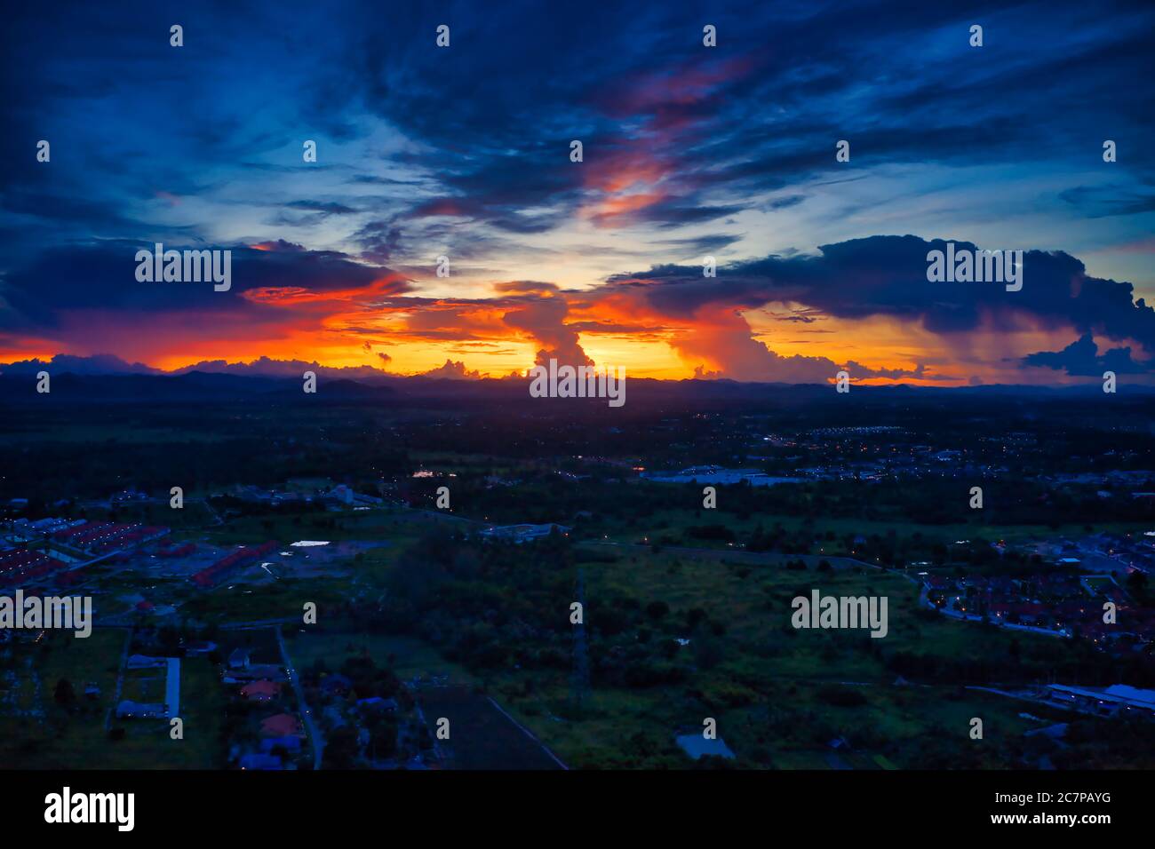Questa foto unica mostra il paesaggio posteriore di Hua Hin in Thailandia durante un tramonto con un cielo grande. È anche possibile vedere una catena montuosa sul retro. Foto Stock