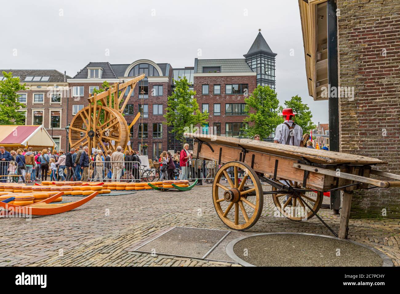Alkmaar, Olanda del Nord / Paesi Bassi. 11 Giugno. 2016. Cart di legno, formaggi al mercato del formaggio in piazza Waagplein della città, un molino di legno Foto Stock