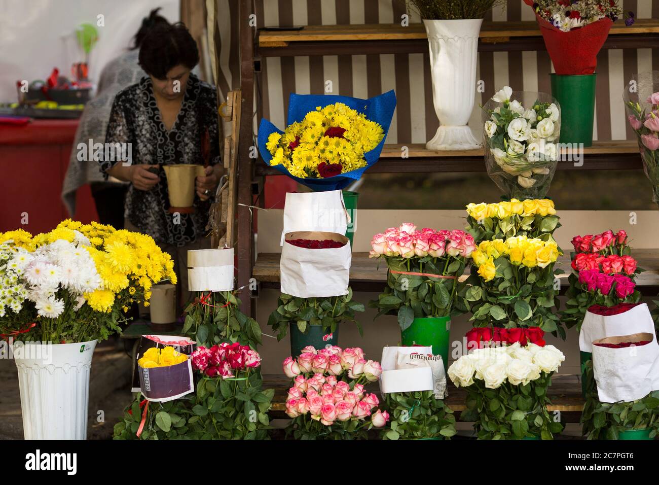 Un portatore del negozio di fiori si prepara per il commercio del fine settimana presto una Domenica mattina a Yerevan, Armenia. Foto Stock