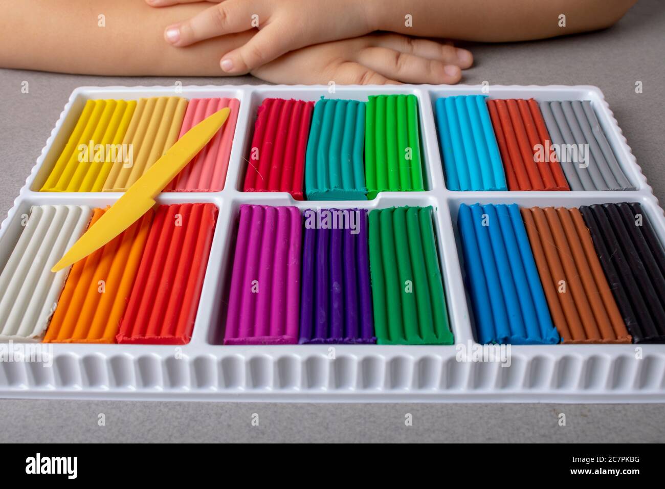 Bastoncini di plastilina colorati in una scatola di cartone. Concetto di giochi educativi Foto Stock
