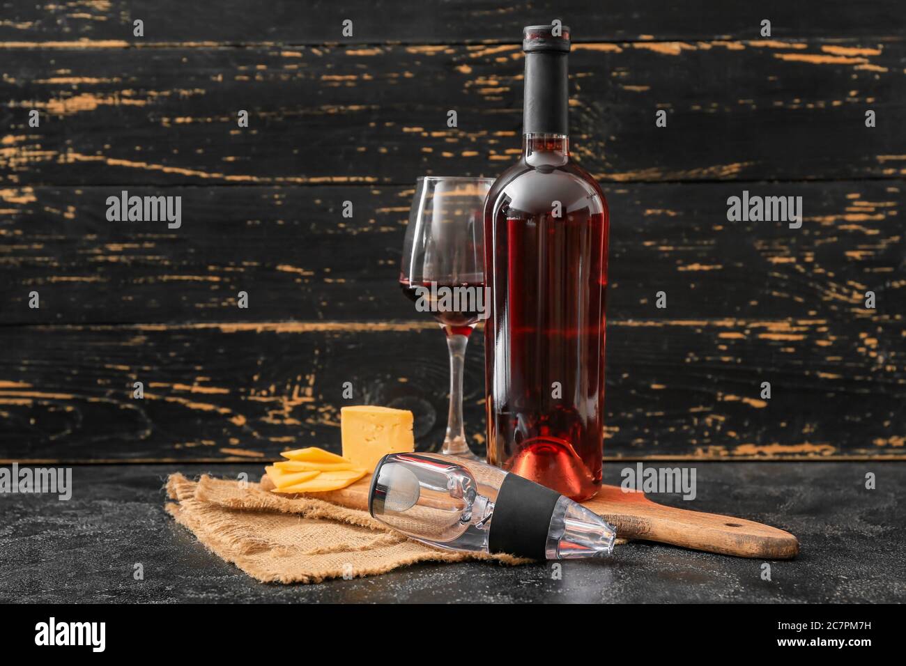 Aeratore con bicchiere, bottiglia di vino e formaggio su fondo scuro Foto  stock - Alamy