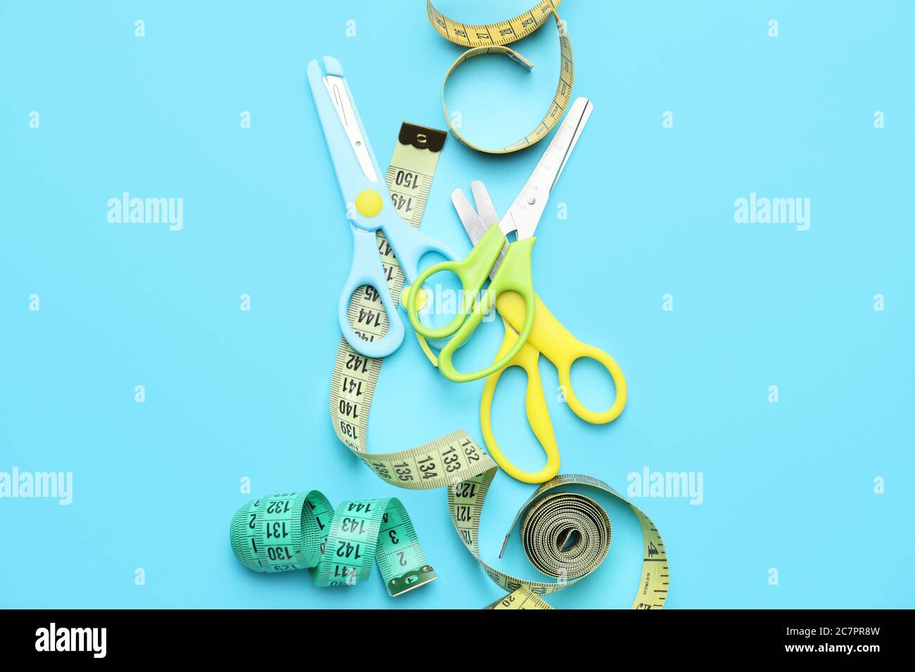 Forbici con nastri di misurazione su sfondo colorato Foto Stock