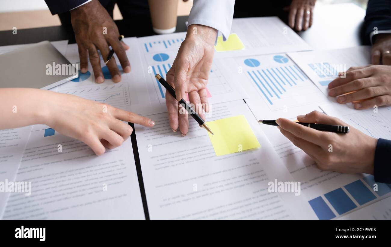 Il personale discute il rapporto in grafici e grafici che analizzano le statistiche finanziarie Foto Stock