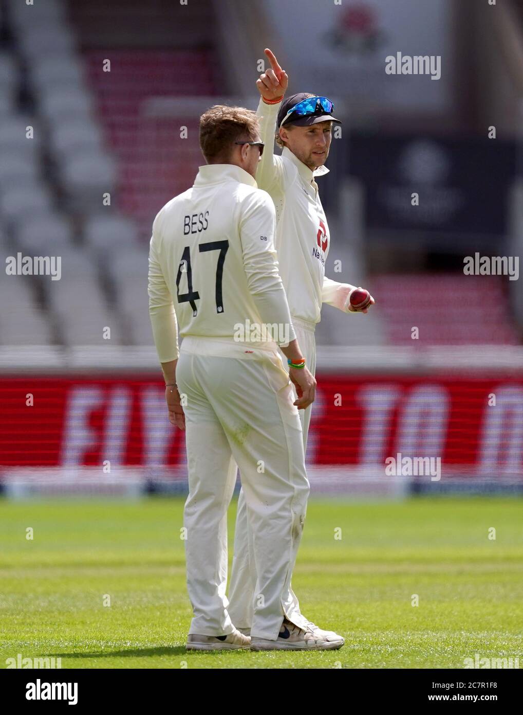 Joe Root, in Inghilterra, prepara il campo mentre Dom Bess si prepara a ciotola durante il quarto giorno del secondo test a Emirates Old Trafford, Manchester. Foto Stock