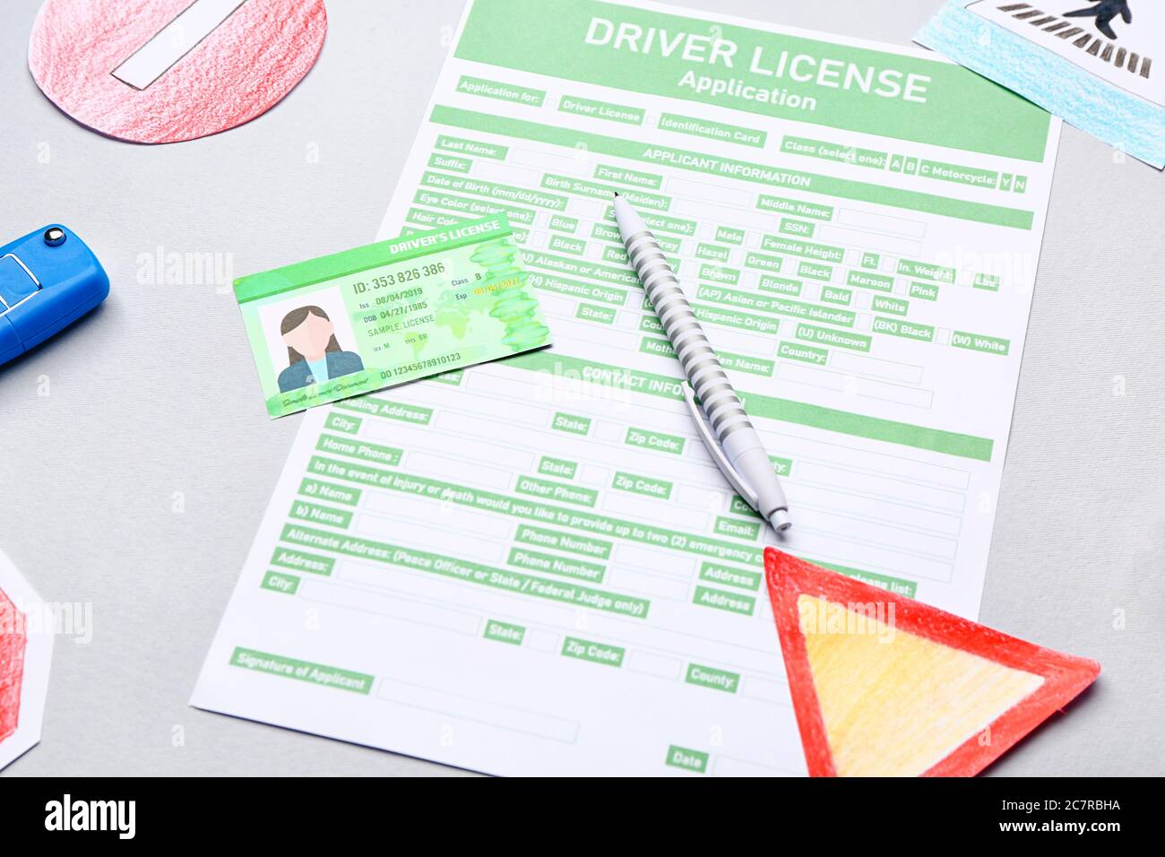 Patente di guida con modulo di richiesta su sfondo grigio Foto Stock