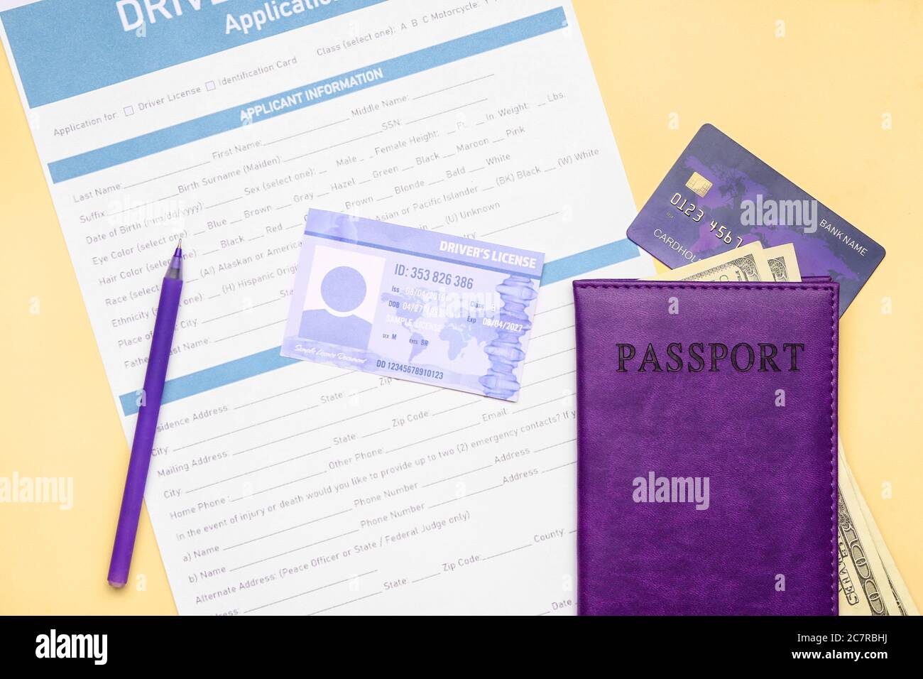 Patente di guida con modulo di richiesta, passaporto e denaro su sfondo a colori Foto Stock