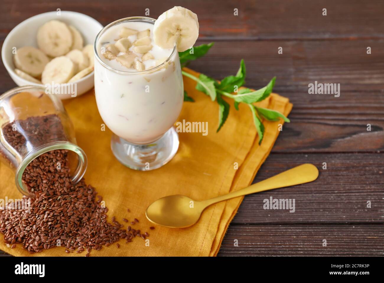 Bicchiere di yogurt con banana e semi di lino su sfondo di legno Foto stock  - Alamy