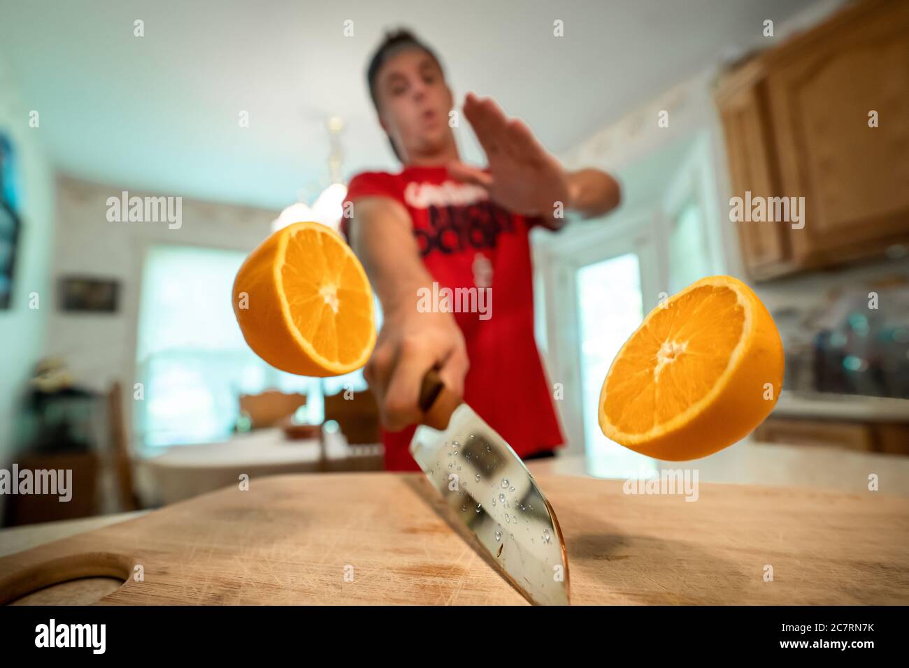 Primo piano delle due metà di un arancione in l'aria tagliata da un maschio sullo sfondo Foto Stock