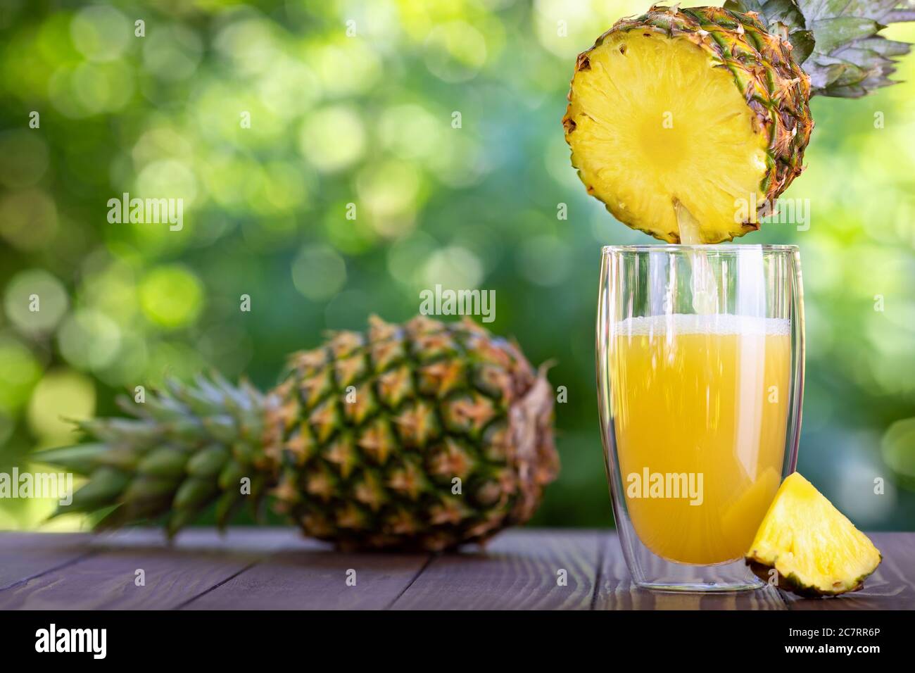 succo di ananas che si versa in un bicchiere Foto Stock