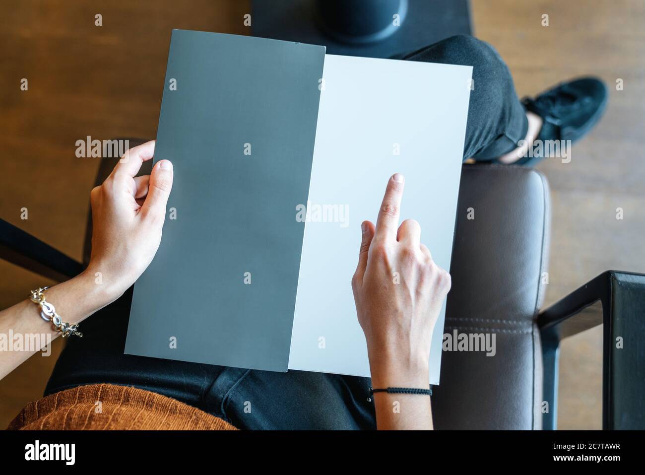 la donna sta tenendo e puntando su una pagina vuota come texture modello, scheda, menu o brochure . Foto di alta qualità Foto Stock
