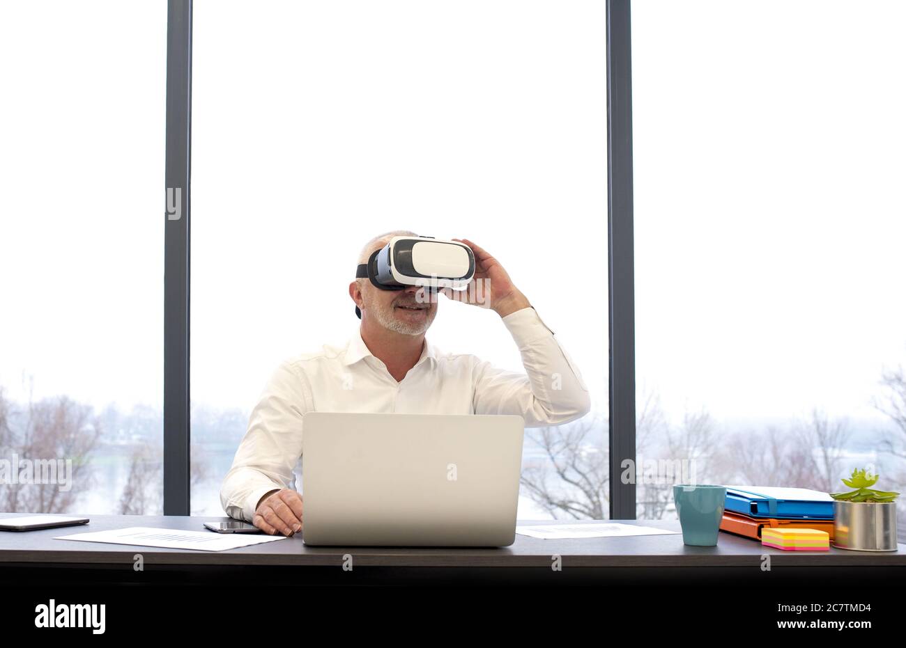 Un uomo in un visore VR che gode di una presentazione virtuale del progetto a. l'ufficio Foto Stock