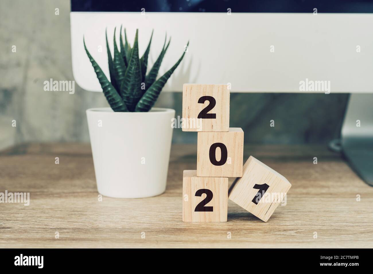 2021 felice anno nuovo su legno blocco su legno tavolo computer desktop e pentola pianta. nuovo anno concetto Foto Stock
