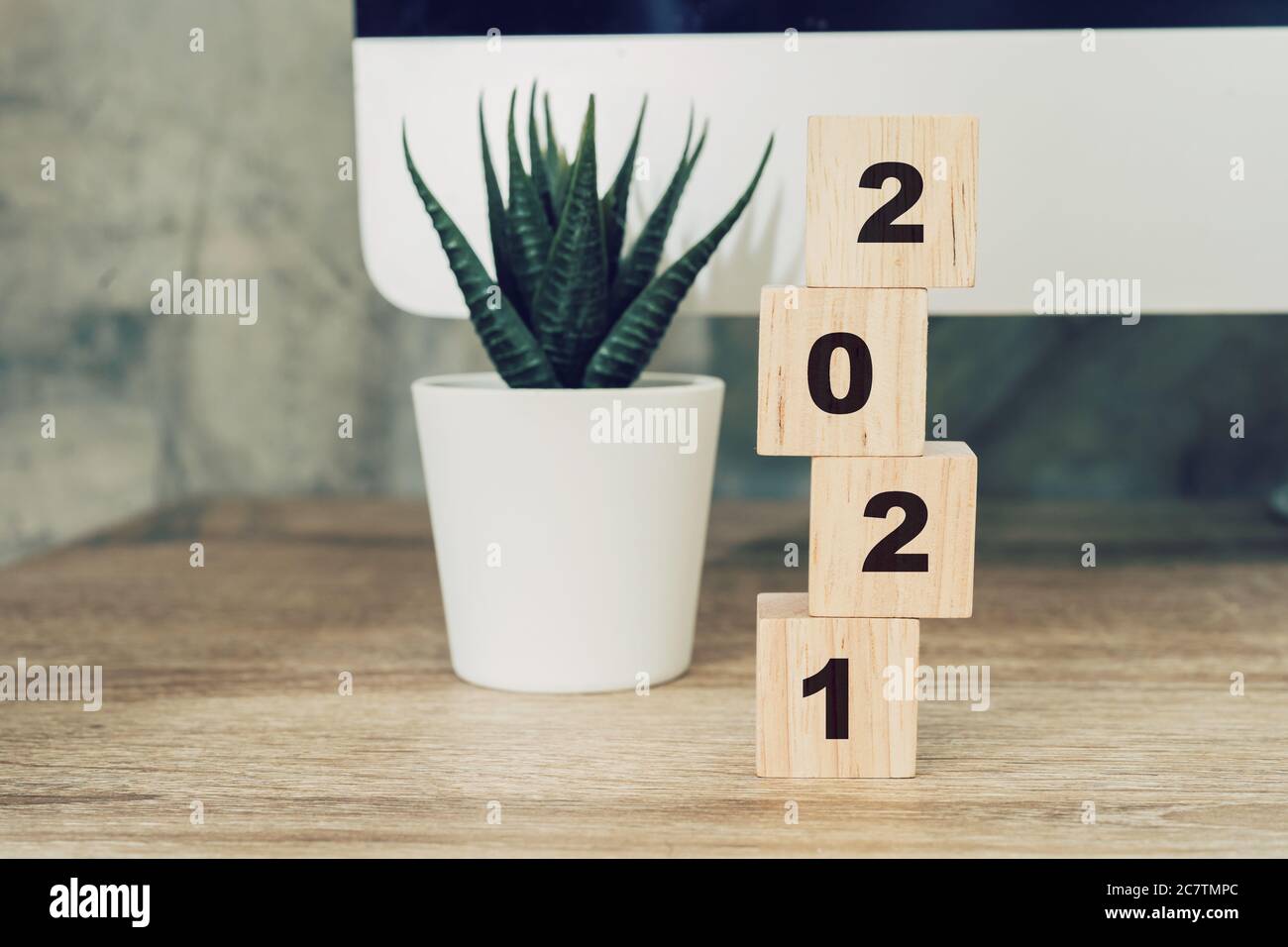 2021 felice anno nuovo su legno blocco su legno tavolo computer desktop e pentola pianta. nuovo anno concetto Foto Stock