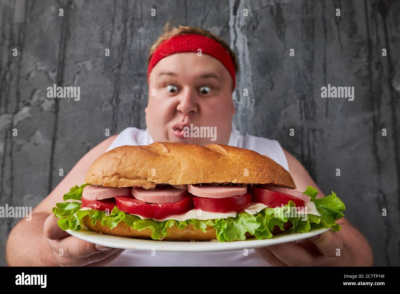 bell'uomo grasso caucasico che va a mangiare un grande panino gustoso, non è imbarazzato dal suo peso in eccesso, eata ciò che vuole Foto Stock