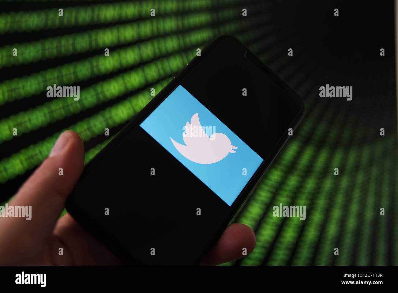 Viersen, Germania - 9 luglio. 2020: Visualizzazione sul telefono cellulare con il logo twitter tenuto a mano. Schermo con tunnel di numeri di codice binario sfondo.(selective Foto Stock