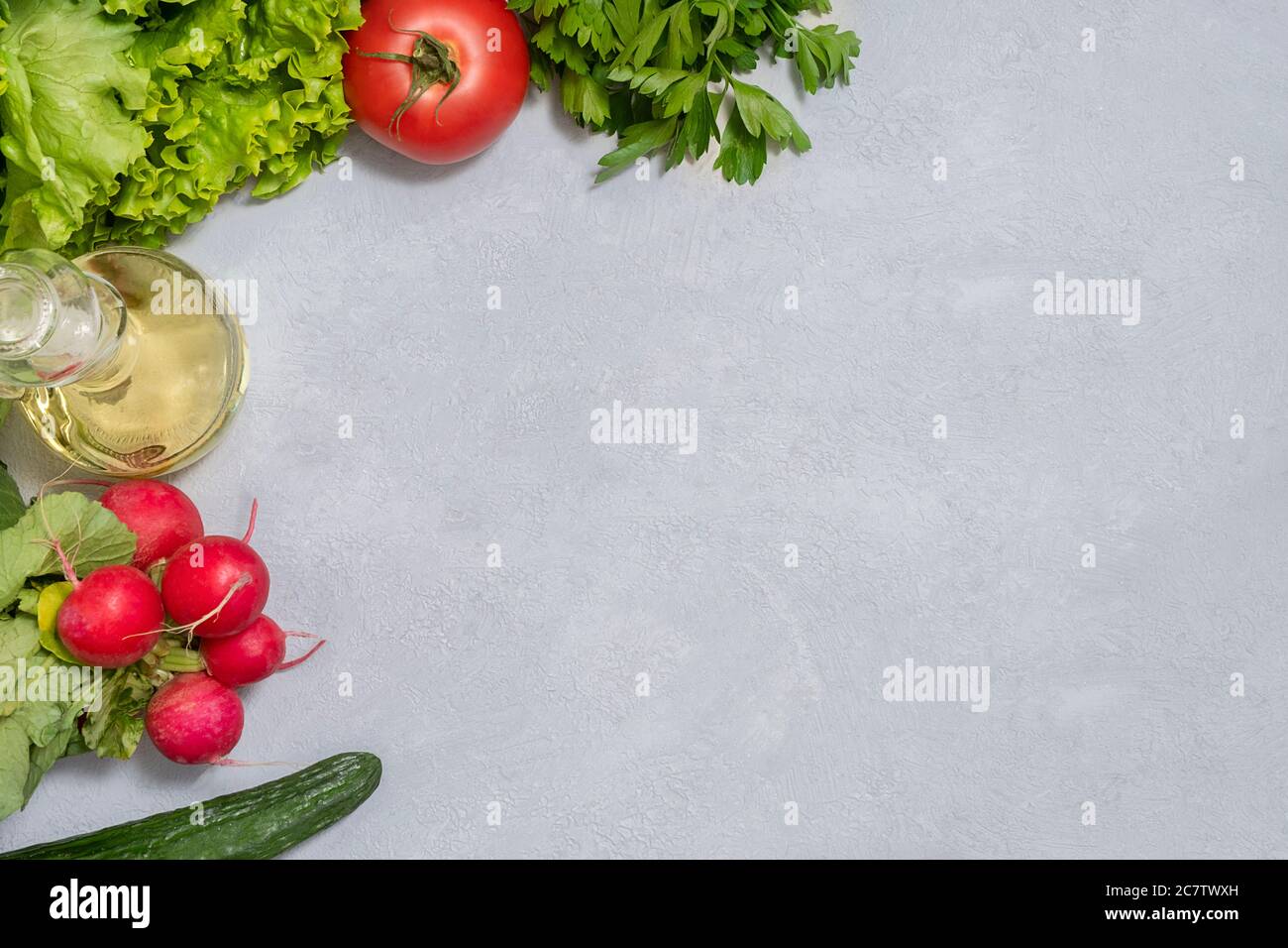 Ingredienti freschi di insalata cruda su fondo neutro di cemento con spazio di copia, vista dall'alto. Verdure o vegetariane Foto Stock