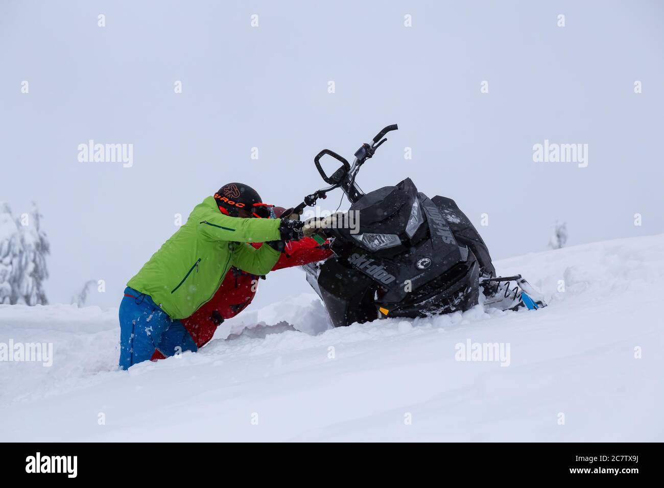 Le persone avventurose stanno recuperando una motoslitta Foto Stock