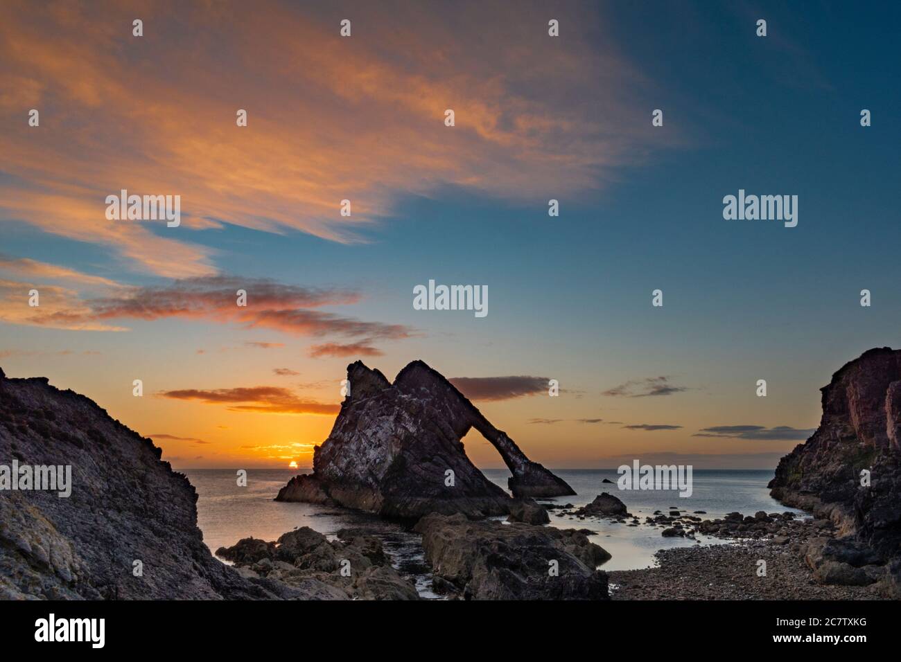 ARCO FIODLE ROCK PORTKNOCKIE MORAY COSTA SCOZIA ESTATE UNA MATTINA ALBA A LUGLIO BASSA MAREA NUVOLE COLORATE E SOLE APPENA IN AUMENTO Foto Stock