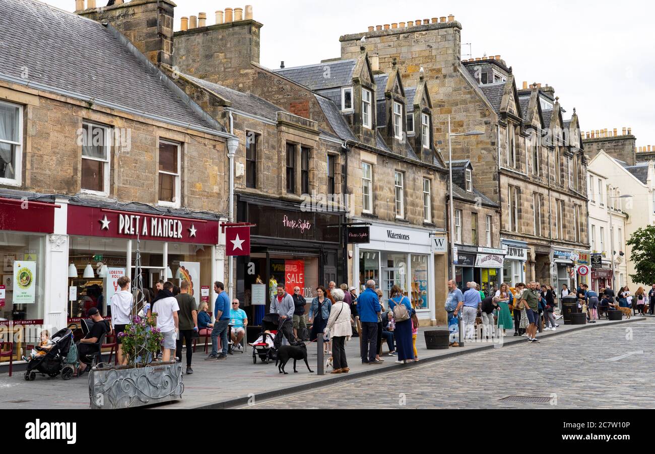 Vista delle persone e dei negozi lungo la trafficata Market Street nel centro di St Andrews, Scozia, Regno Unito Foto Stock