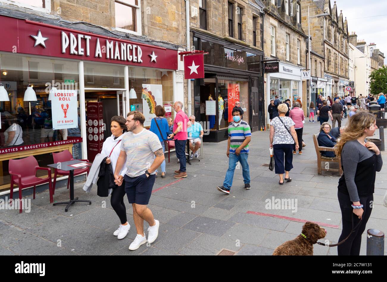 Vista delle persone e dei negozi lungo la trafficata Market Street nel centro di St Andrews, Scozia, Regno Unito Foto Stock