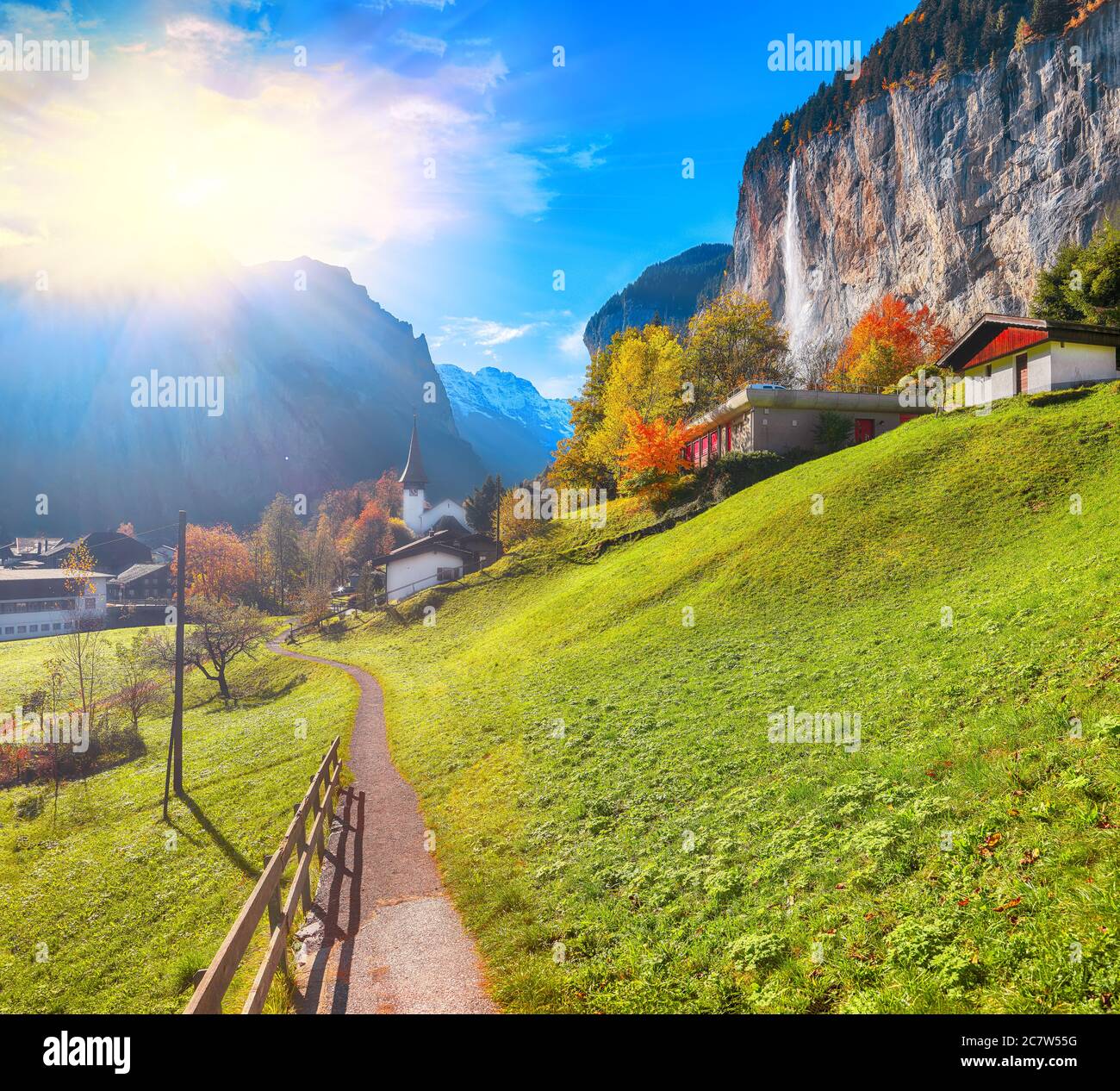 Fantastica vista autunnale del villaggio di Lauterbrunnen con la cascata Staubbach e le Alpi svizzere sullo sfondo. Ubicazione: Lauterbrunnen villaggio, Foto Stock