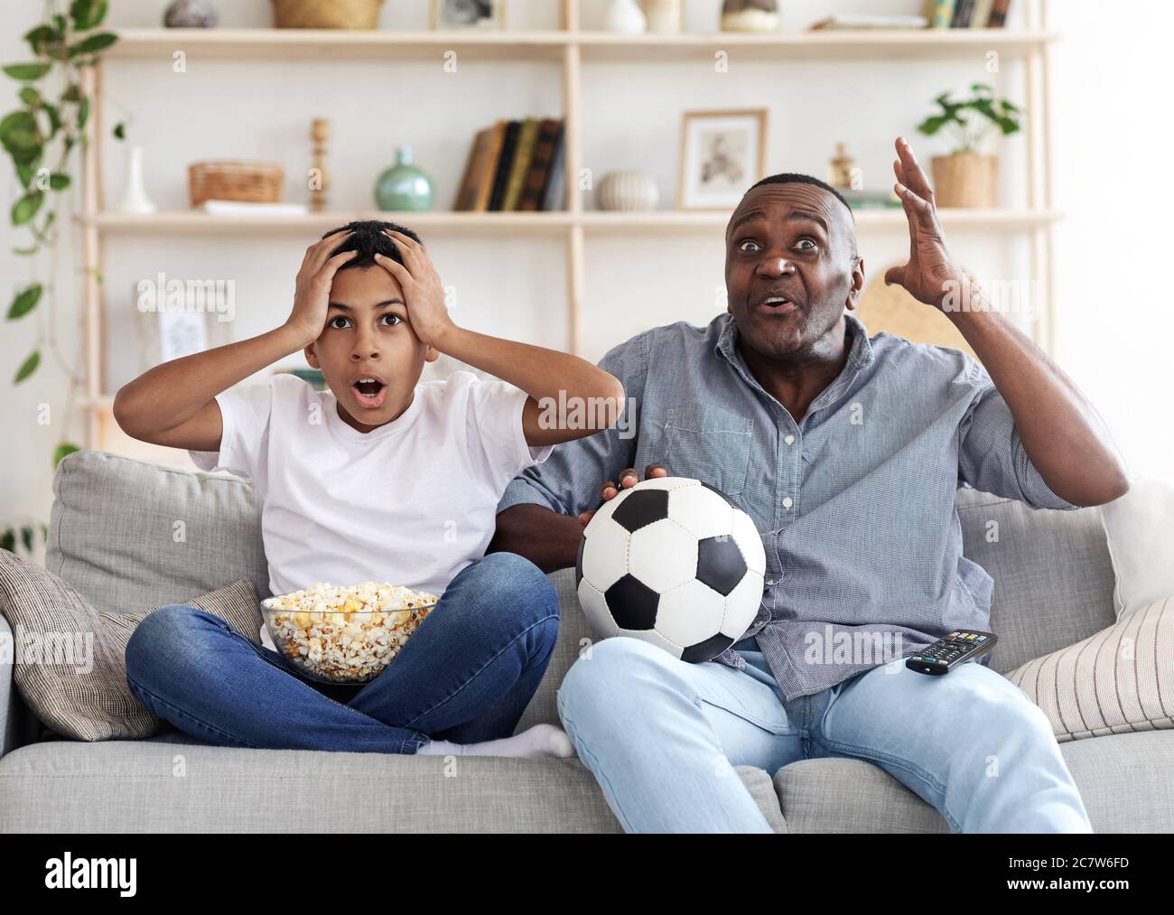 Obiettivo perso. Deluso il nonno nero e suo nipote che guardano il calcio in TV Foto Stock