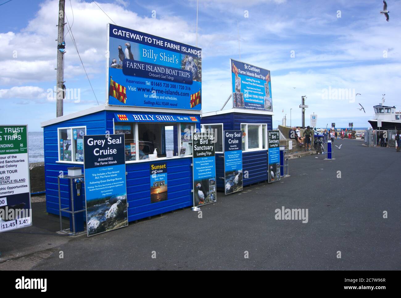 Chioschi che vendono biglietti per gite in barca sul molo al porto di Seahouses, Northumberland, Regno Unito. Foto Stock