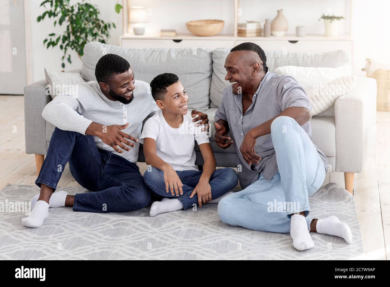 Tempo con la famiglia. Black Boy che si lega a papà e nonno a casa Foto Stock