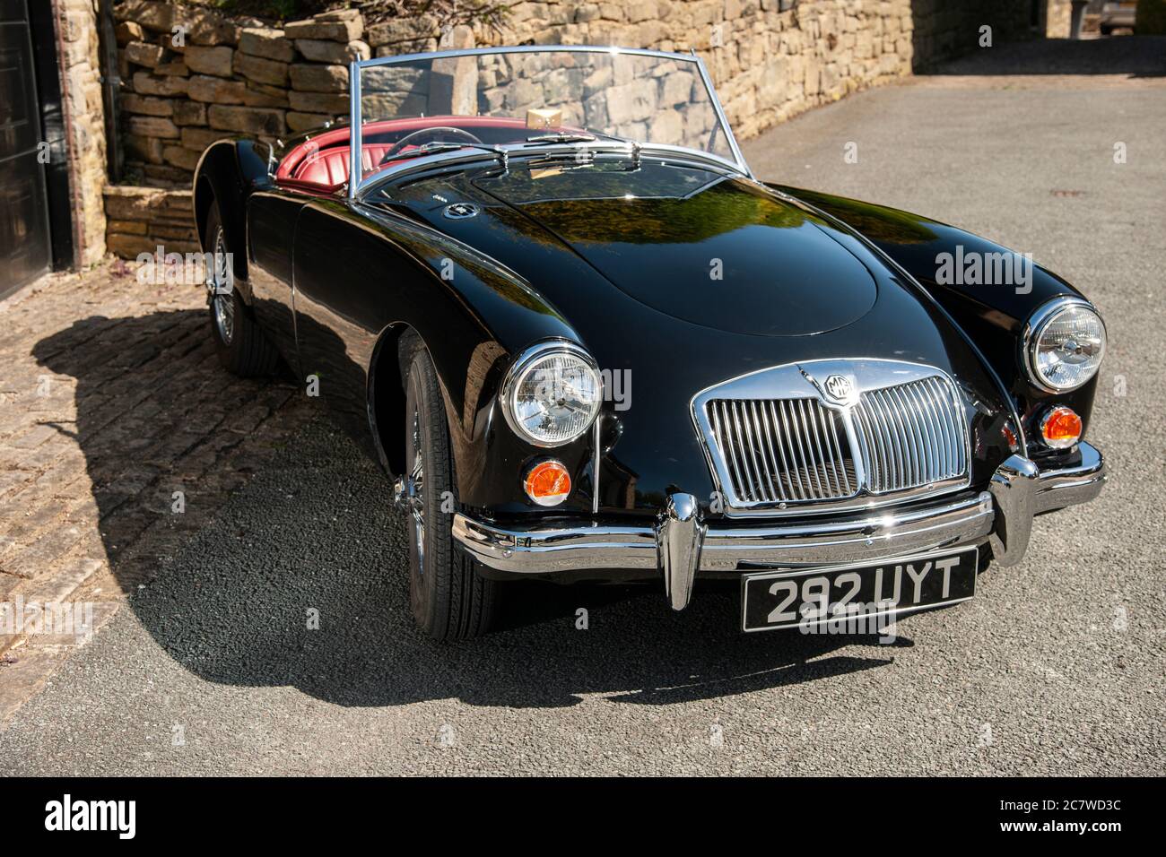 Un nero Nineteen Fifties MGA roadster parcheggiato su una corsia stretta da una garae di pietra, in una soleggiata giornata estiva nello Yorkshire Foto Stock