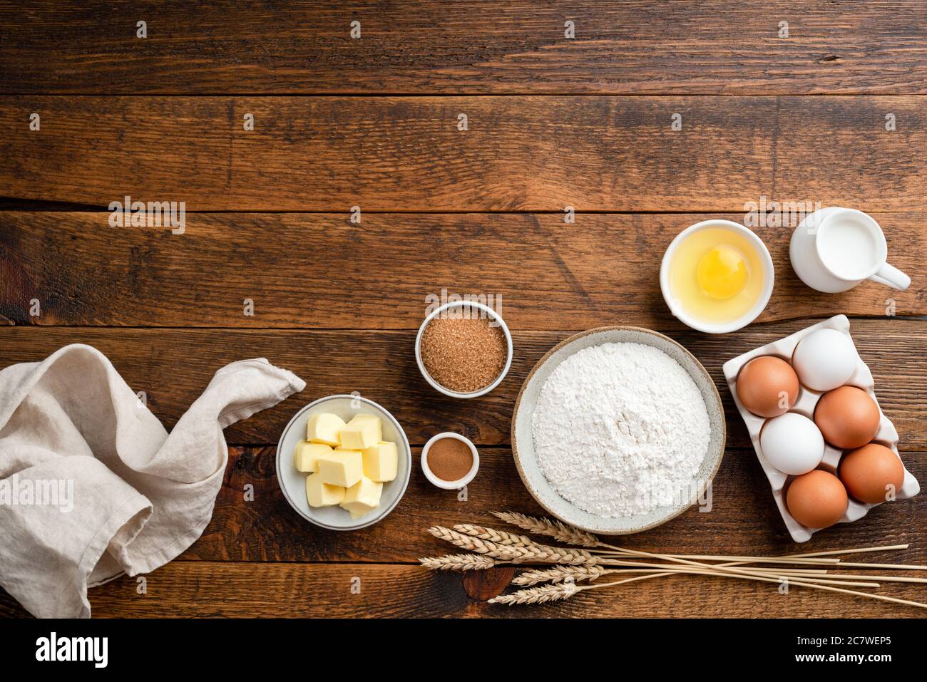 Ingredienti per la cottura su fondo rustico in legno. Farina, uova, burro, zucchero e altri ingredienti per preparare una torta, una pasta per pane dolce o un biscotto Foto Stock