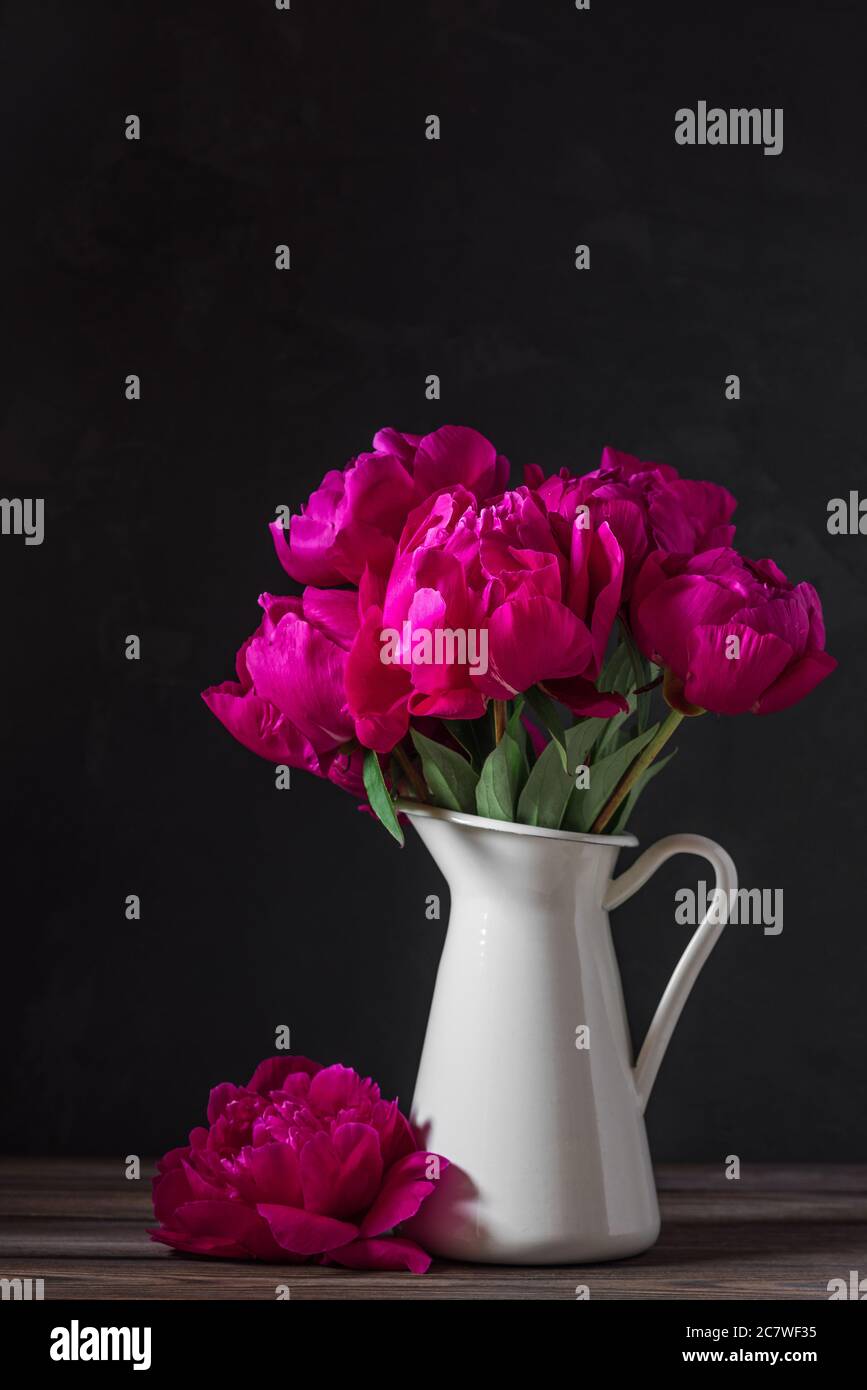bouquet di fiori di colore rosso su sfondo scuro. vita still. tasto basso. sfondo festivo. orientamento verticale Foto Stock