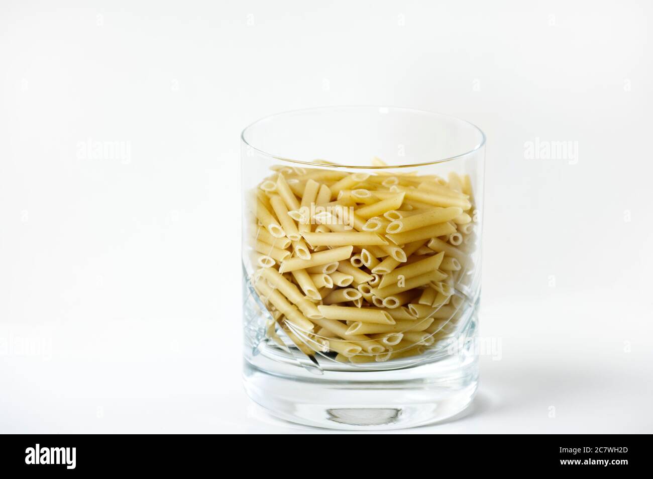 Maccheroni biologici in una tazza di vetro preparata per la cottura. Foto Stock