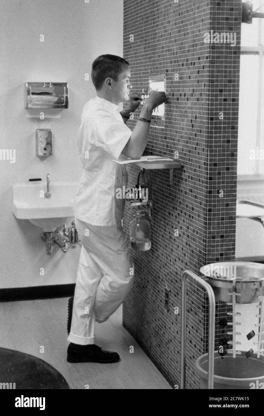 Philadelphia, Pennsylvania. Circa.1960 - Un dentista che esamina i raggi X dentali in chirurgia dentale. Foto Stock