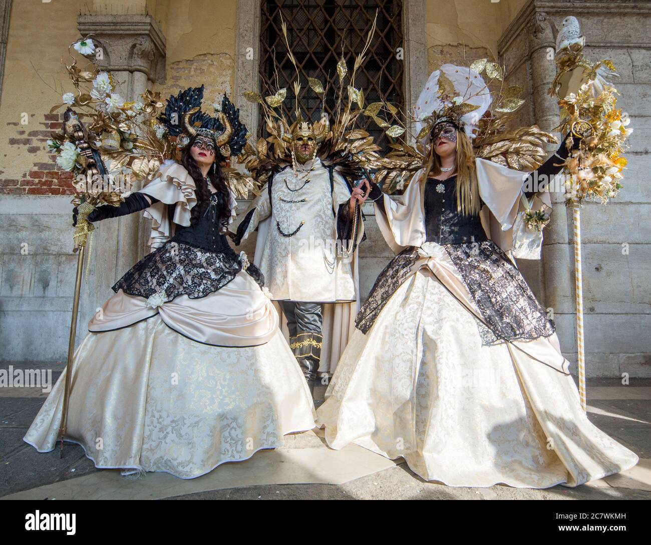Trio di persone durante il Carnevale di Venezia con maschere e costumi di  carnevale in bianco, nero e oro Foto stock - Alamy