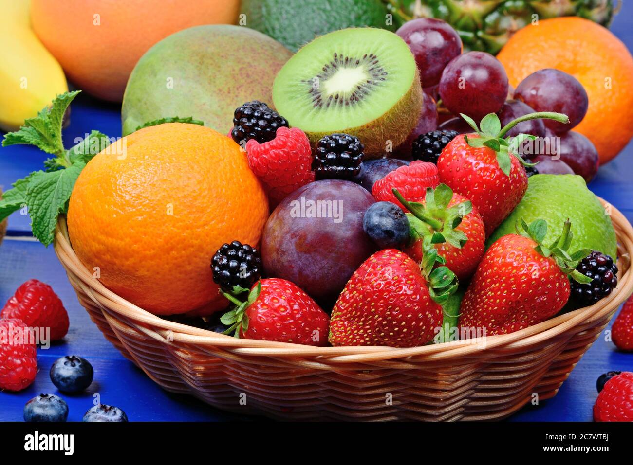 Mescolare la frutta colorata in un cestino su un tavolo di legno Foto Stock