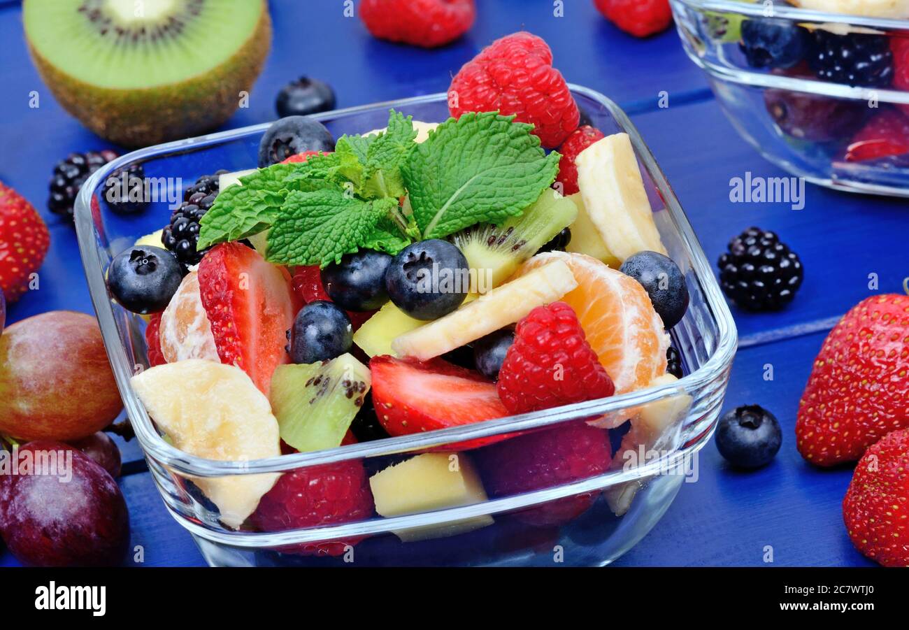 Insalata di frutta fresca colorata in ciotole sul tavolo Foto Stock