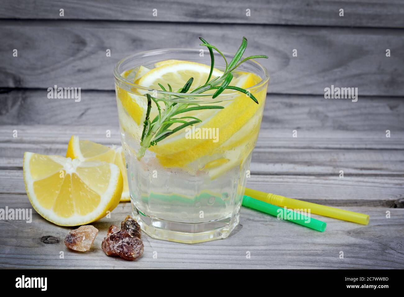 Bicchiere con acqua e limone su tavolo di legno Foto Stock