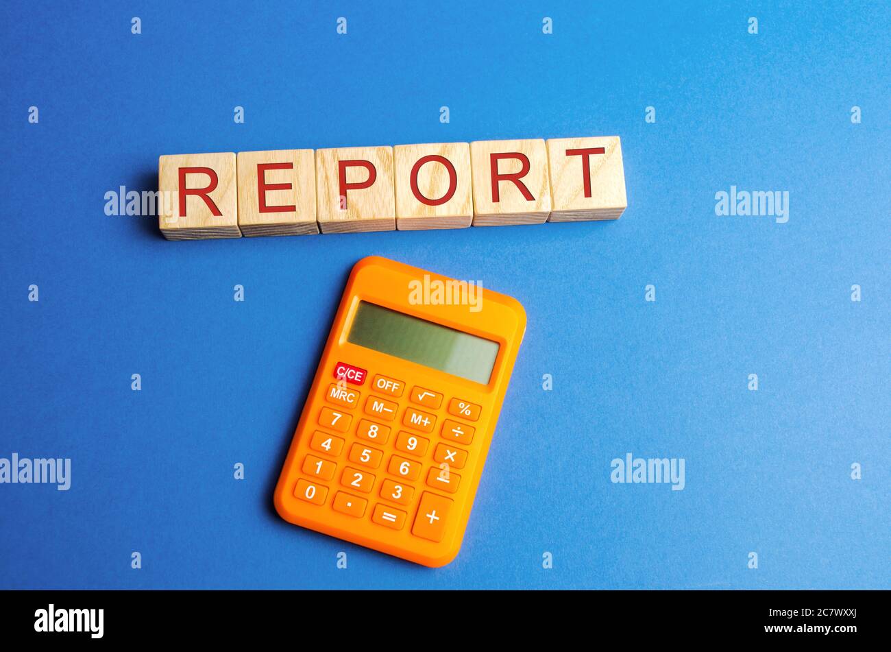 Blocchi di legno con la parola rapporto e calcolatrice. Concetto di reporting finanziario aziendale. Valutazione della situazione finanziaria. Verifica. Profitto, budget, Foto Stock