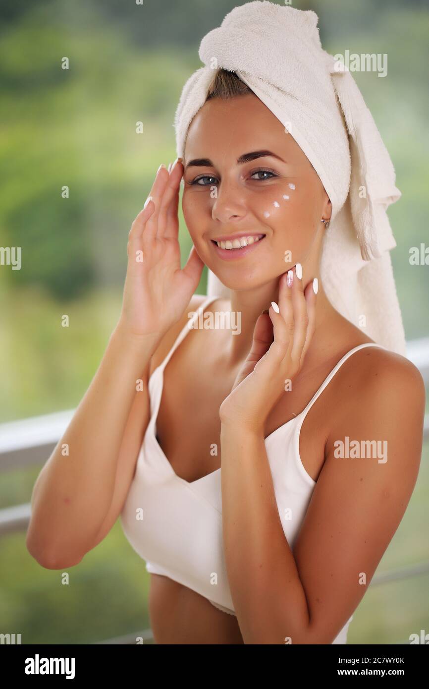 Bella ragazza spa. Toccandola il viso, bellezza e salute Foto Stock