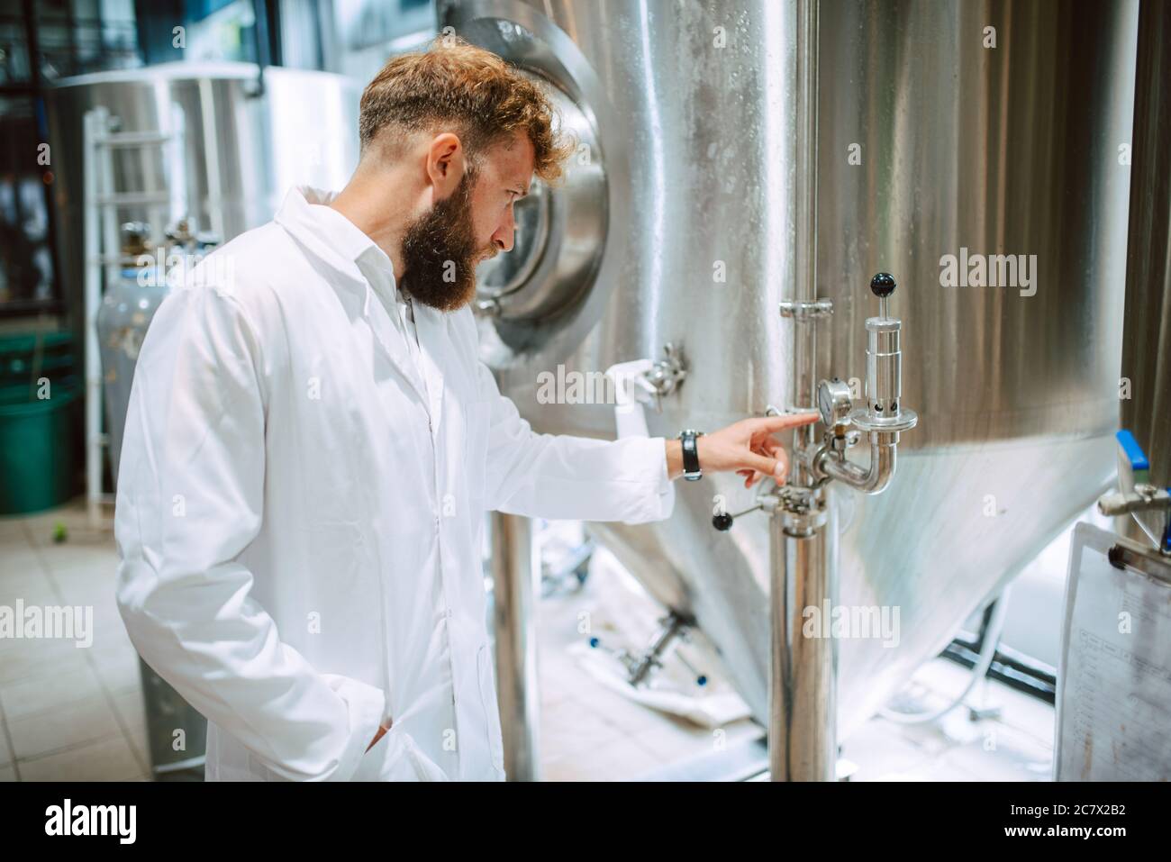 Tecnico caucasico esperto professionale di controllo dei processi industriali in impianti di produzione. Lavoratore industriale con produttività di controllo uniforme Foto Stock