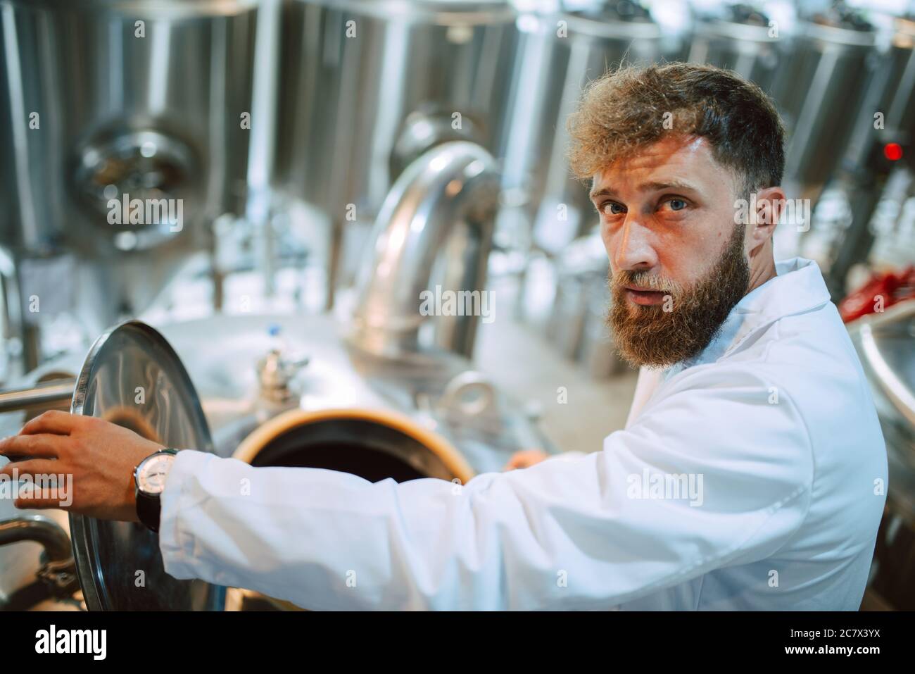 Tecnico caucasico esperto professionale di controllo dei processi industriali in impianti di produzione. Lavoratore industriale con produttività di controllo uniforme Foto Stock