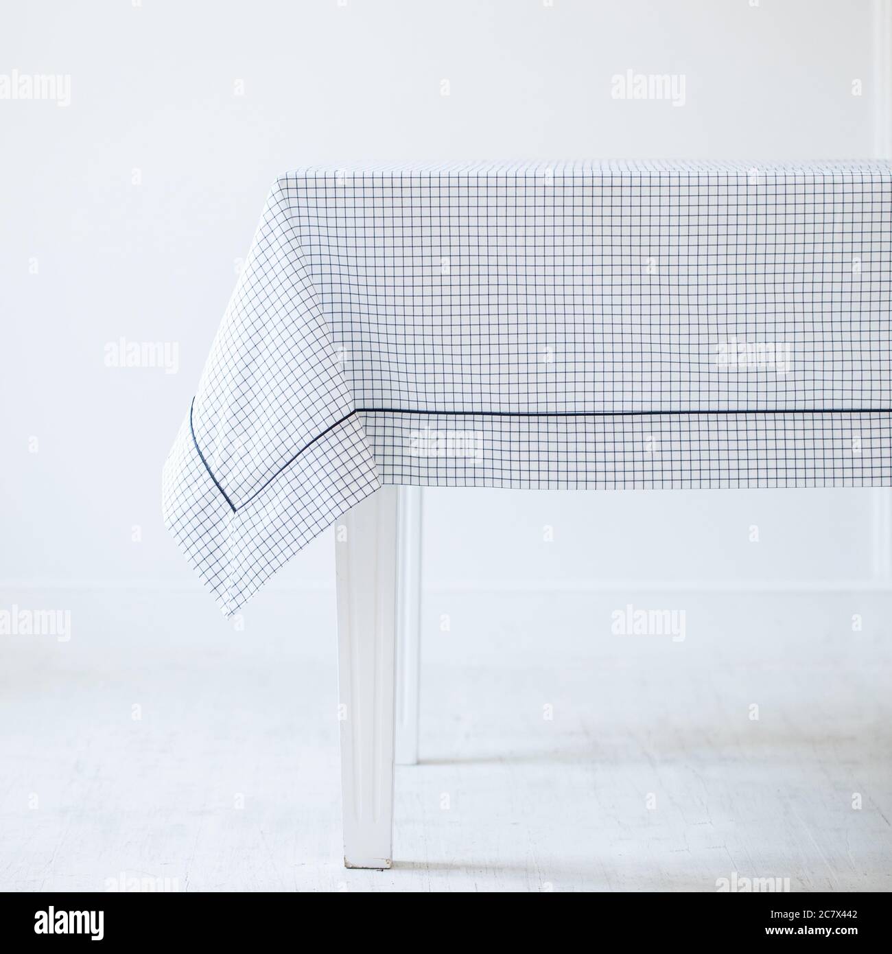 Tavolo di legno bianco con un elegante tovaglia con nero e. texture bianche Foto Stock