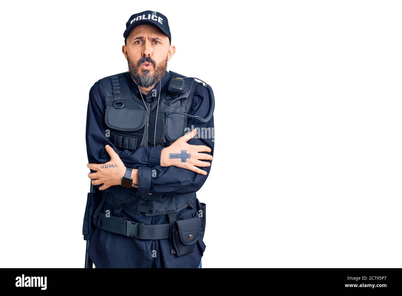 Giovane bell'uomo che indossa uniforme della polizia scuotendo e congelando per il freddo invernale con espressione triste e shock sul viso Foto Stock