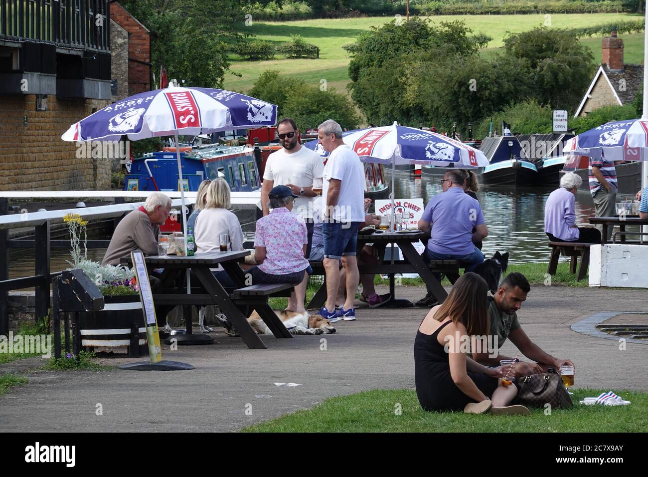 Stoke Bruerne Canal, Northants, UK - 19 luglio 2020: La gente fuori gustando un drink e un caldo pomeriggio di Domenica. L'Inghilterra rilassa le regole del Coronavirus covid 19. Foto Stock