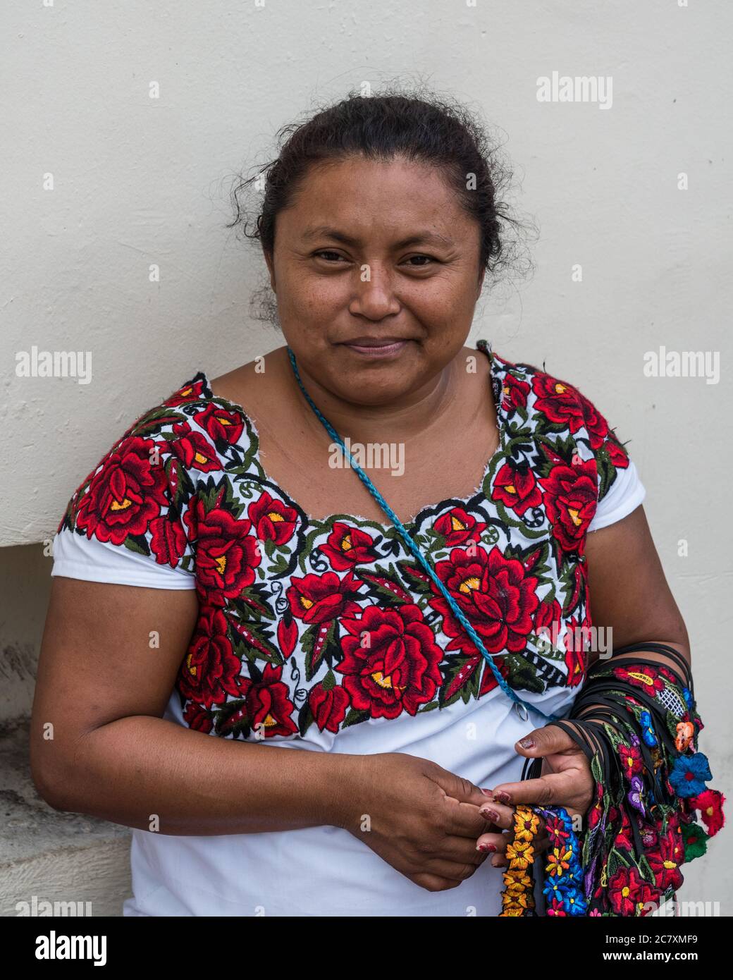 Una donna Maya nel suo tradizionale ricamato huipil vendere oggetti di artigianato per strada a Valladolid, Yucatan, Messico. Foto Stock