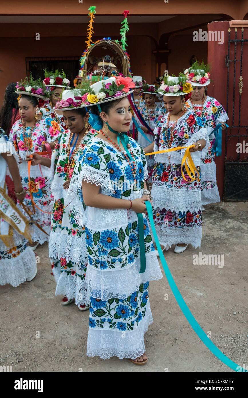 Le donne in hiipil ricamati e cappelli fioriti festive si preparano per la Danza della testa del maiale e del tacchino, o Baile de la cabeza del Foto Stock