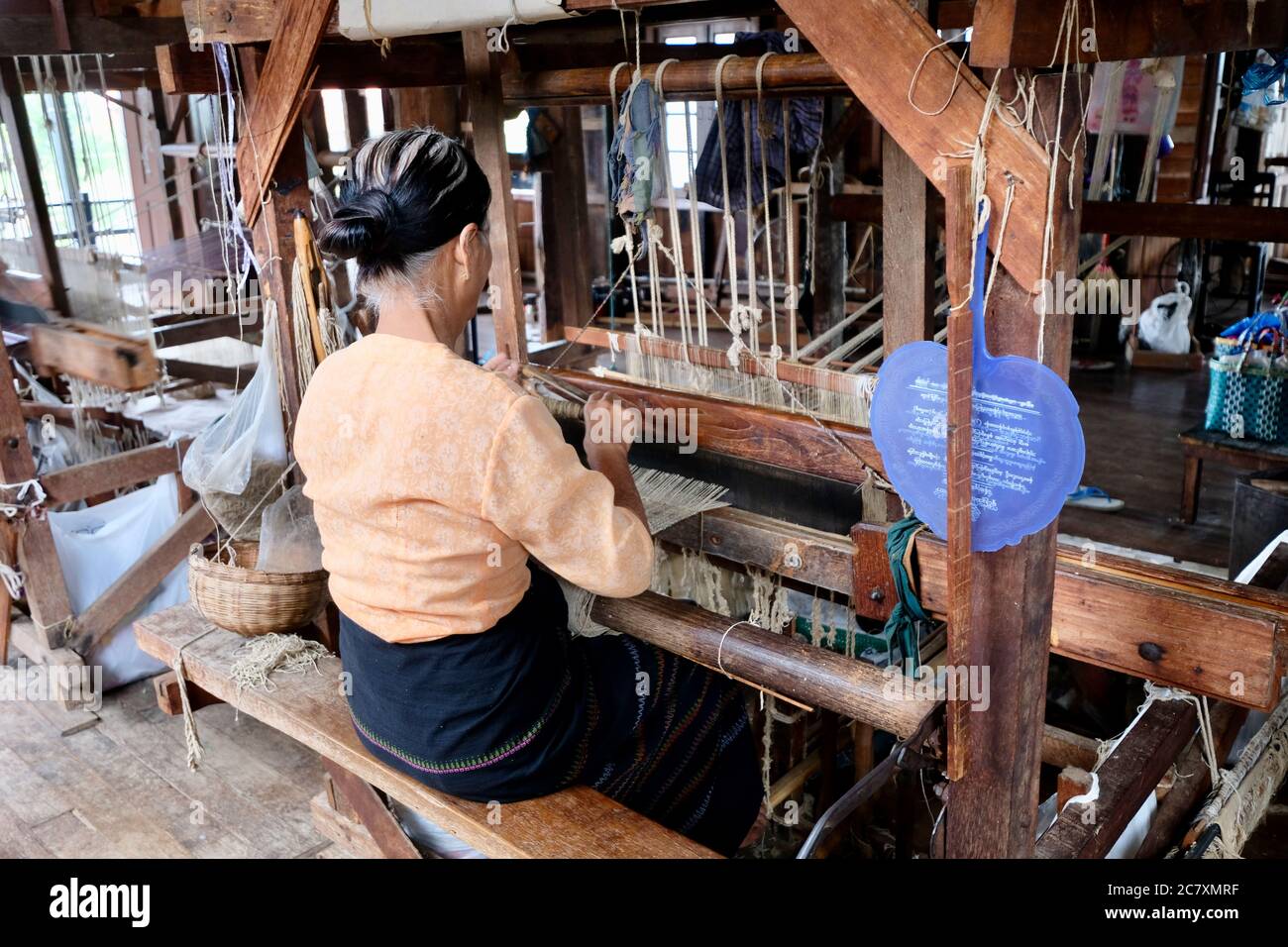 Una donna birmana seduto al telaio di legno. Utilizzando fibra di radice di loto con cotone e seta per fare sciarpa e longyi. Industria tradizionale nel lago di Inle Foto Stock