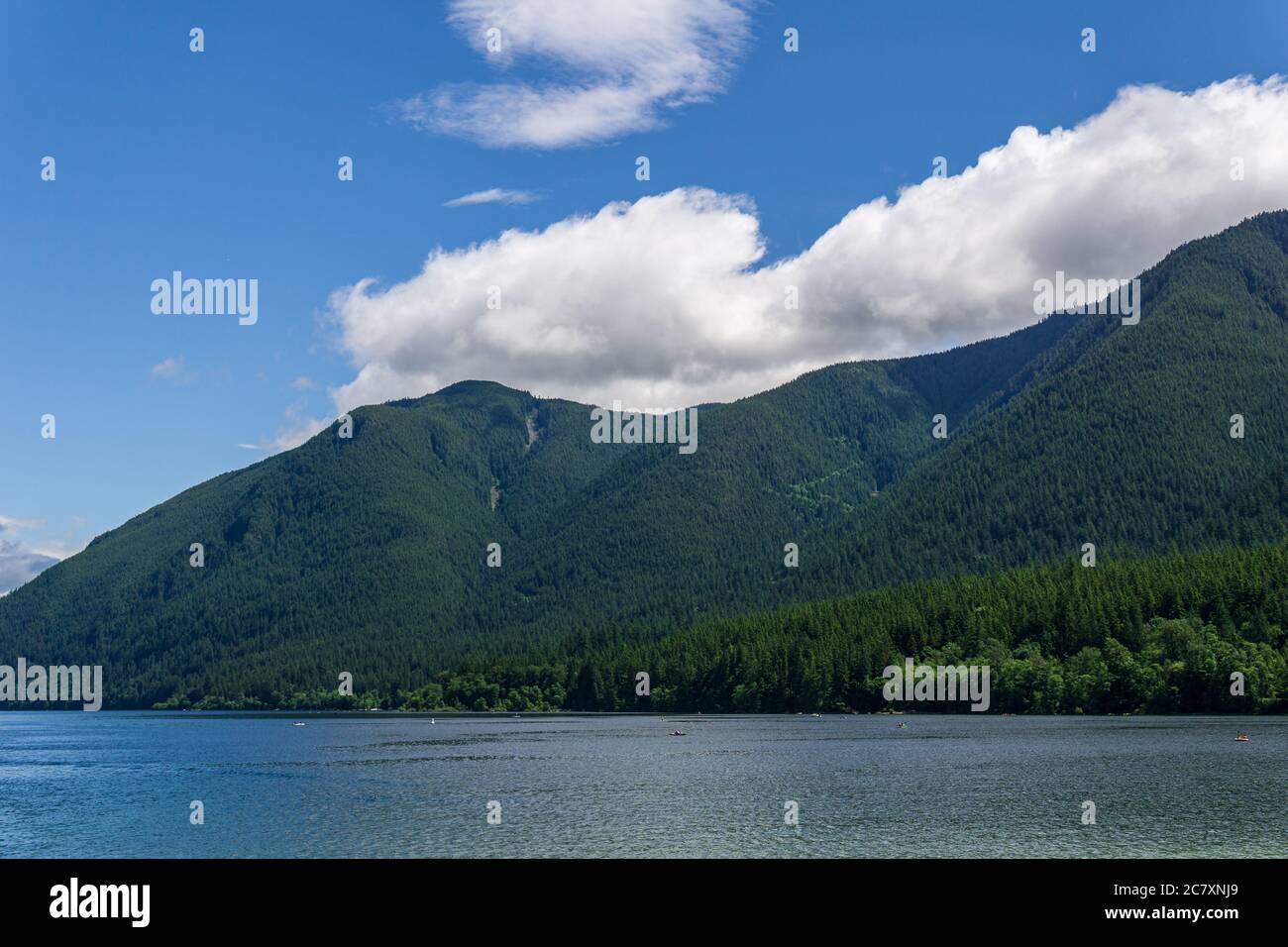 lago di montagna blu con montagne verdi cielo blu e nuvole bianche Foto Stock